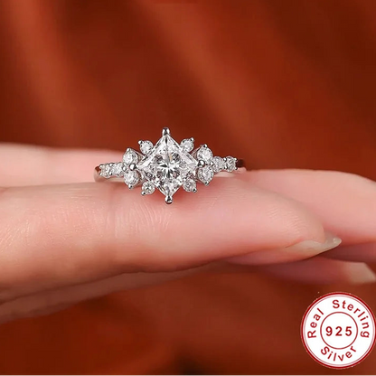 Silver ring with a princess cut moissanite on a finger