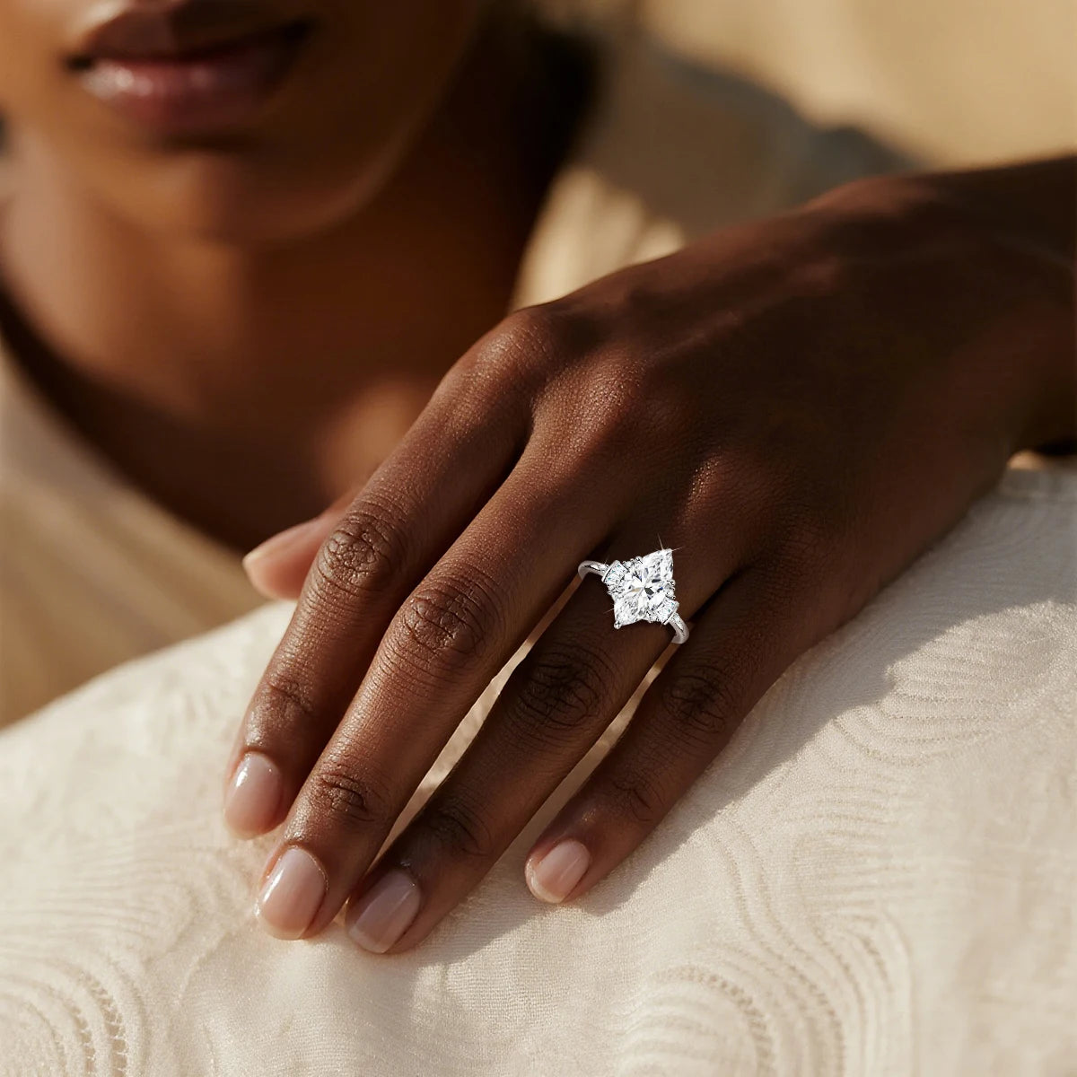 Close-up of a hand wearing a diamond ring on a textured surface