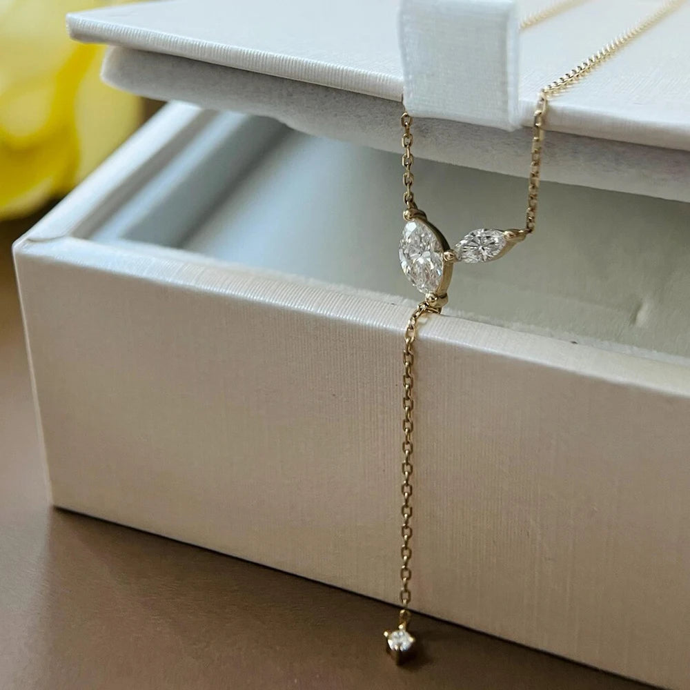Gold necklace with a pendant on a white jewelry box