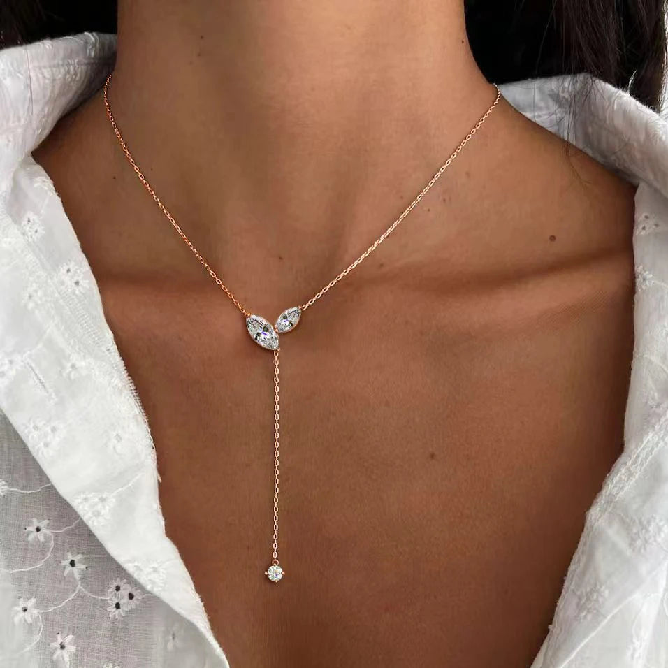 Rose gold necklace with a y-style design worn by a person against a white background