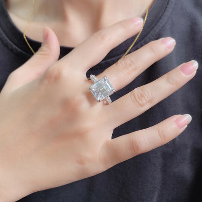 Hand wearing a diamond ring with a dark background