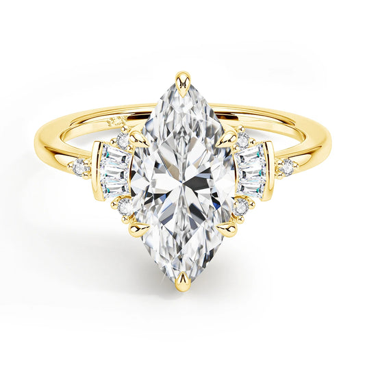 Gold ring with a large pear-shaped diamond and smaller side stones on a white background