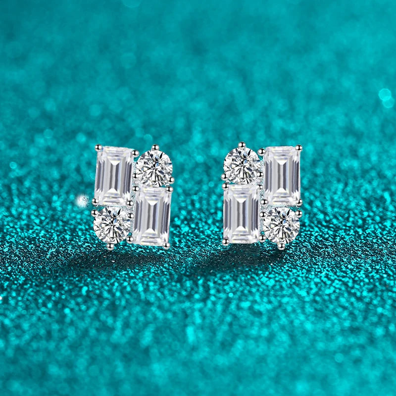 Pair of diamond earrings on a teal glittery background