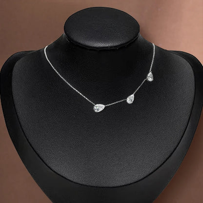 Silver necklace on a black mannequin bust against a brown background