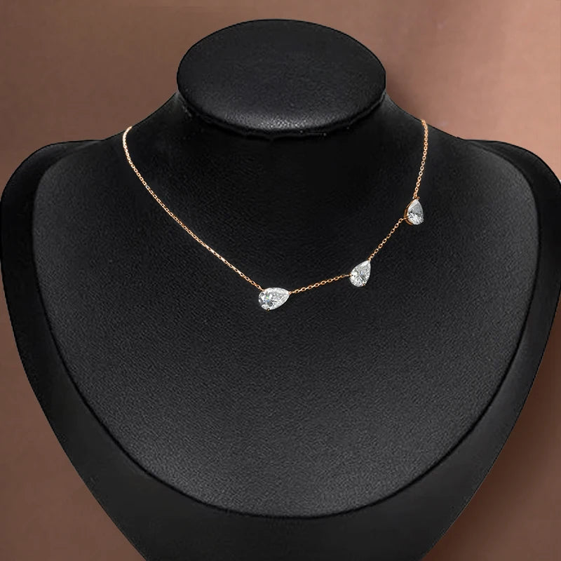 Necklace with teardrop-shaped crystals on a black mannequin bust against a brown background