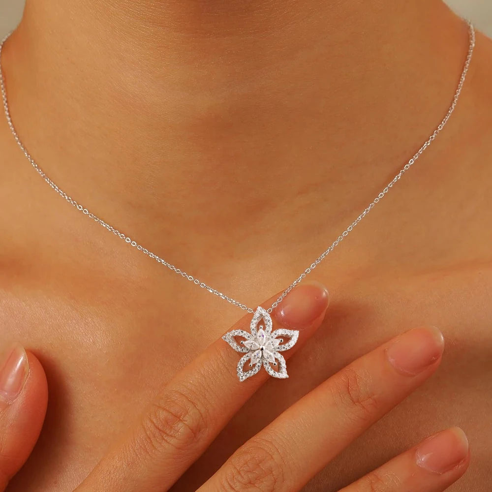 Silver necklace with a floral pendant on a person's neck