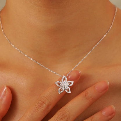 Silver necklace with a floral pendant on a person's neck