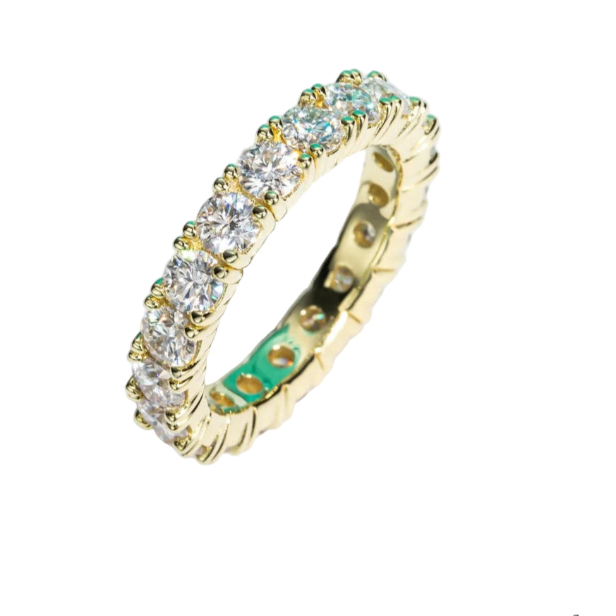 Gold ring with Moissanite stones on a light background