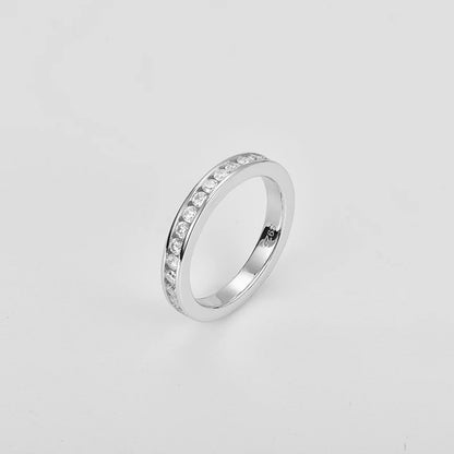 Silver ring with small diamonds on a light gray background