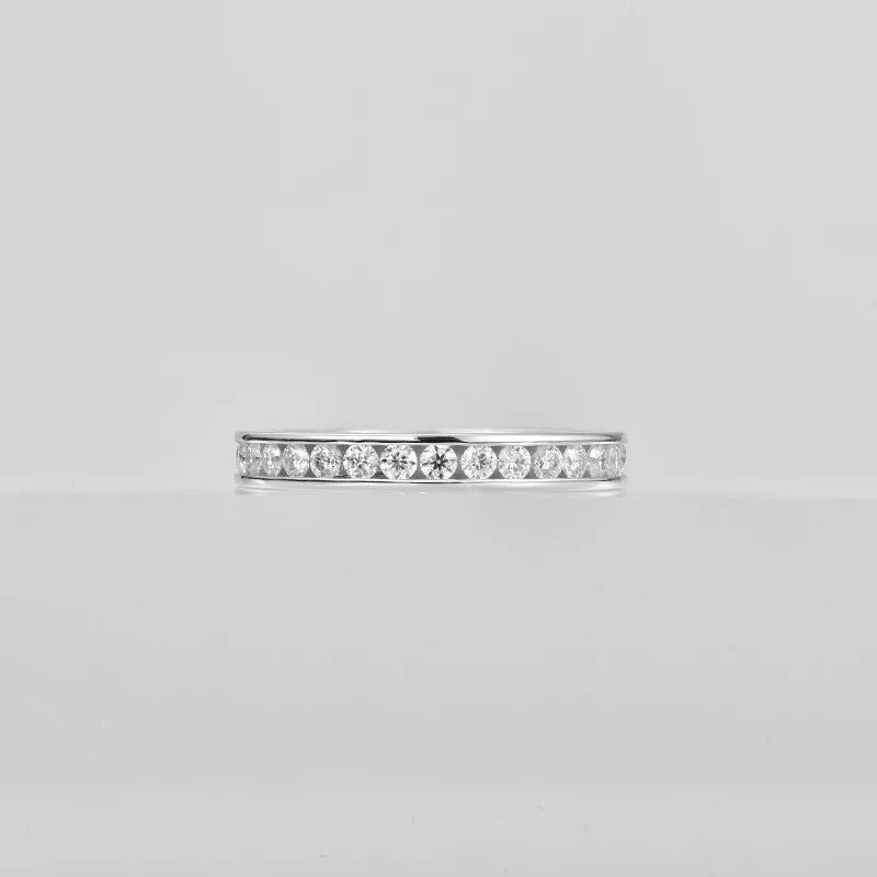 Silver ring with small diamonds on a light gray background