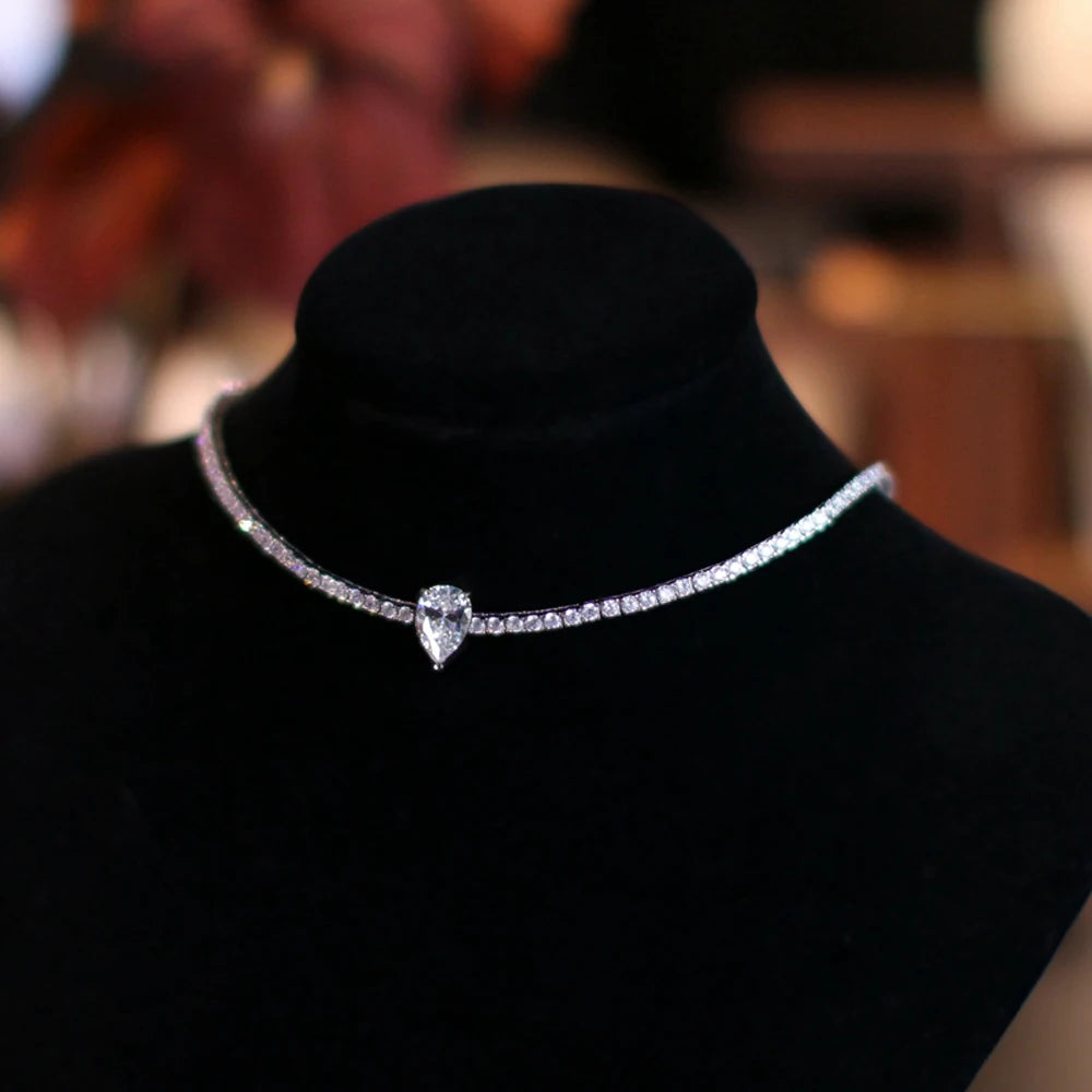 Silver necklace with a heart-shaped pendant on a black mannequin against a blurred background