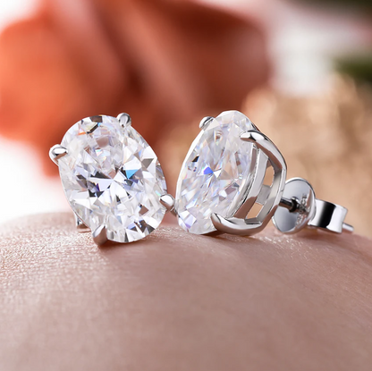 Pair of diamond stud earrings on a blurred background