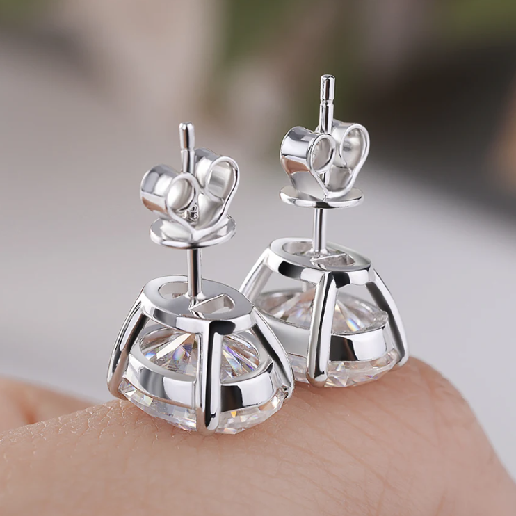 Silver earrings with clear gemstones on a blurred background
