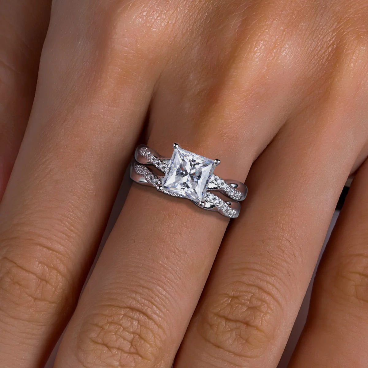 Diamond ring on a finger with a neutral background